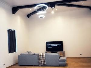 a living room with a couch and a flat screen tv at Grande maison moderne 5 chambres in Cherbourg en Cotentin
