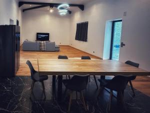 a large wooden table in a room with a couch at Grande maison moderne 5 chambres in Cherbourg en Cotentin