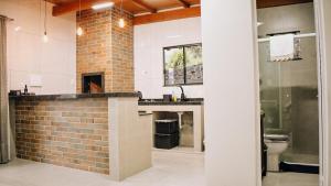a bathroom with a brick wall and a sink at Tiny House - Centro Concórdia in Concordia