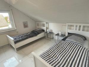a bedroom with two beds and a window at Ferienwohnung am See in Eriskirch +2 photos