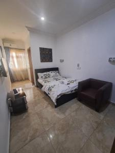 una camera da letto con un letto e una sedia di Shortlet apartment a Port Harcourt