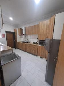 una cucina con armadi in legno e frigorifero nero di Shortlet apartment a Port Harcourt