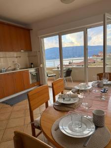 een keuken en eetkamer met een tafel met glazen erop bij Savina apartment Herceg Novi in Herceg-Novi