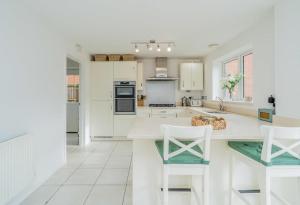 a white kitchen with white appliances and white cabinets at 5 Bedroom Detached House in Milton Keynes in Bletchley