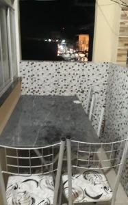 a table and chairs on a balcony at night at Porto apartamento in Porto Seguro