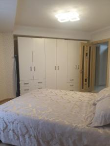 a bedroom with white cabinets and a large bed at Ботаника , парк долина роз аеропорт in Chişinău +14 photos