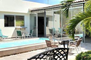 a patio with a table and chairs next to a pool at Casa Finca Jaccuzi Aire Acondicionad Wifi TV in Ricaurte
