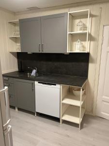a kitchen with white cabinets and a black counter top at Leilighet med 3 soverom nær sentrum in Kristiansand