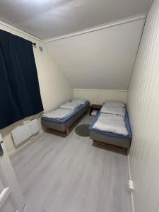 a small room with two beds and a window at Leilighet med 3 soverom nær sentrum in Kristiansand