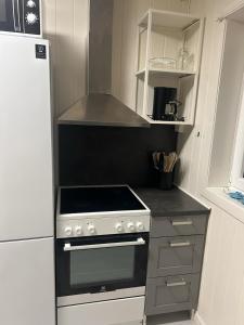 a kitchen with a stove and a refrigerator at Leilighet med 3 soverom nær sentrum in Kristiansand +6 photos