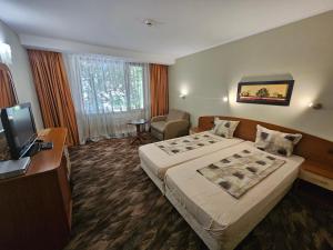 a hotel room with a bed and a television at Family Hotel Jeri in Velingrad