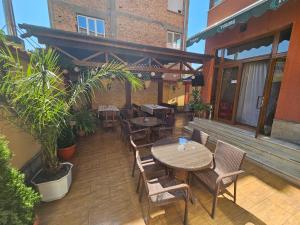 an outdoor patio with tables and chairs and plants at Family Hotel Jeri in Velingrad