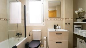 Un baño con inodoro, lavabo y ventana. en H&H Suite Granada Apartament, en Armilla 25 fotos más