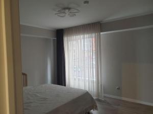 a bedroom with a bed and a window at Ботаника Тесцимициану Молл парк долина роз in Chişinău