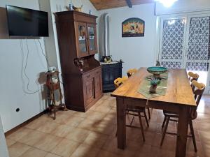 comedor con mesa de madera y TV en Leo cozy apartment, en Castel di Sangro