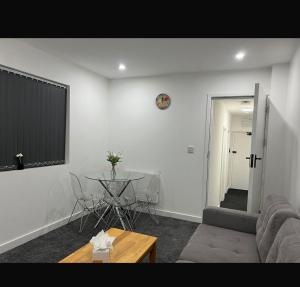 a living room with a couch and a table at Luton Centrally Located Apartment v close London Luton Airport in Luton +1 photo