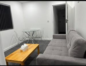 a living room with a couch and a table at Luton Centrally Located Apartment v close London Luton Airport in Luton