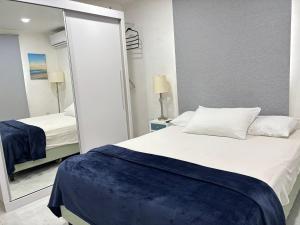 a bedroom with a white bed and a mirror at The Almas Apartment in Willemstad