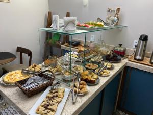 a table with a bunch of different types of food at Pousada Canasvieiras in Florianópolis