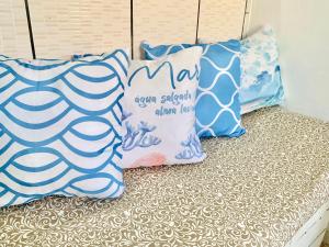 a group of pillows sitting on top of a bed at Sua Kitnet a menos de 5min da Praia in Santa Cruz Cabrália