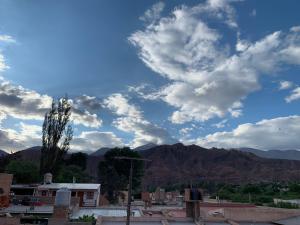 een uitzicht op een stad met bergen en wolken bij Departamento Ayllu IV in Tilcara