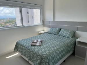 Ένα ή περισσότερα κρεβάτια σε δωμάτιο στο Apartamento de 2 suítes com vista para o mar