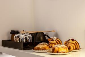 a shelf with several pastries and a tea kettle at Mamalu - Corso Umberto 35 - Studios and Suites in Naples