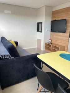 a living room with a couch and a table with chairs at Dallas apartamentos na Via Gastronômica-Estacionamento-Amplos e equipados-Wifi in Bento Gonçalves