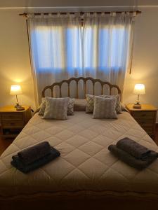 Un dormitorio con una cama grande con almohadas. en Cabañas lodge El Suizo, en Gobernador Virasora
