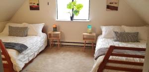 two beds in a room with a window and two tables at Pocono Cabin Fireplace Near Skiing Tubing Parks Shopping Casinos in Pocono Lake