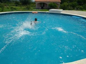 a person in a swimming pool in a large blue pool at Casas de Época - Arrebol in Charbonier