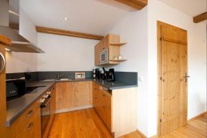 uma cozinha com armários de madeira e um balcão preto em Tauernchalets em Grossarl