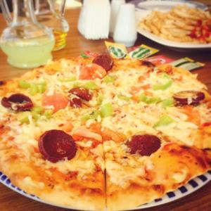 a pizza with pepperoni and peppers on a table at Amore Hotel Teki̇rova in Tekirova