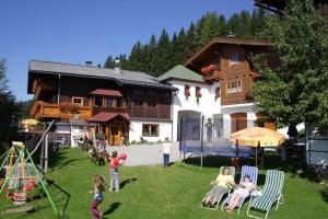 a group of children playing in a yard in front of a house at Berggasthof-Ferienbauernhof Habersatt in Altenmarkt im Pongau
