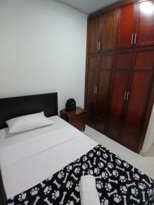 Un dormitorio con una cama y un armario de madera. en Apartamento NUEVO en el Centro de Palmira Apto 2, en Palmira 4 fotos más