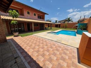 a backyard with a swimming pool and a house at Casa magnífica na praia in Mongaguá +9 photos