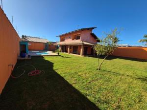 a yard with a house with a garden hose at Casa magnífica na praia in Mongaguá