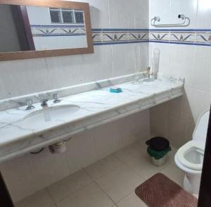 a bathroom with a sink and a toilet at Casa magnífica na praia in Mongaguá
