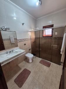 a bathroom with a shower and a toilet and a sink at Casa magnífica na praia in Mongaguá