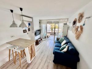 a living room with a blue couch and a table at Chalana II, Cala Salions, Tossa de Mar in Tossa de Mar