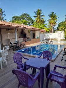 a patio with tables and chairs next to a swimming pool at Casa Veraneio in Soure
