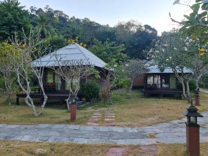 a house with a gazebo in a garden at Thanya Beach Resort - SHA Plus in Ko Ngai