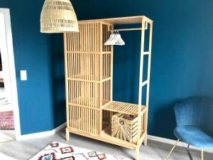 a wooden bird cage in a room with a blue wall at Wohlfühlvilla Garding in Garding