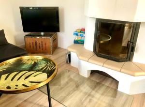 a living room with a tv and a table and a chair at Wohlfühlvilla Garding in Garding