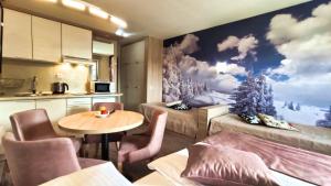 a room with two beds and a table at Apartments KOP Konaci in Kopaonik
