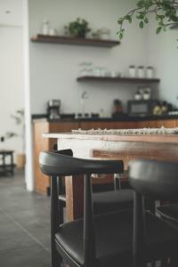 a bar with two stools in front of a counter at K NAJ Community in El Quelele