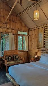 a bedroom with a bed and a couch in it at สวนเกษตรรักษ์ไผ่ Bamboo Conservation Farm in Surin