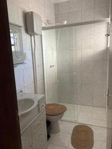 a white bathroom with a toilet and a sink at apartamento 3 quartos in Rosário do Sul