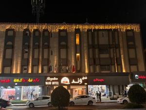 a large building with cars parked in front of it at فندق وند wand hotel in Khawājīyah