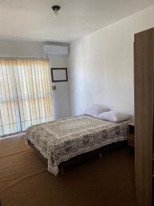 a bedroom with a bed and a window at apartamento 3 quartos in Rosário do Sul +2 photos